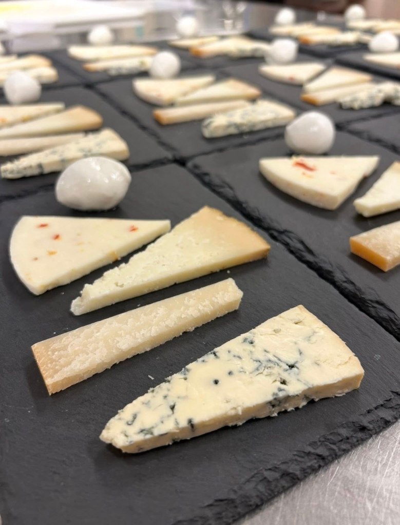 a table covered in slates of cheese flights, each having five slices of cheese